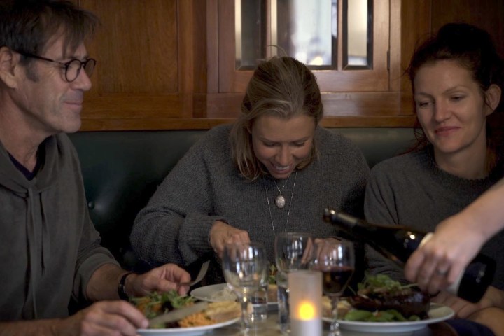 a man and a woman sitting at a table with wine glasses